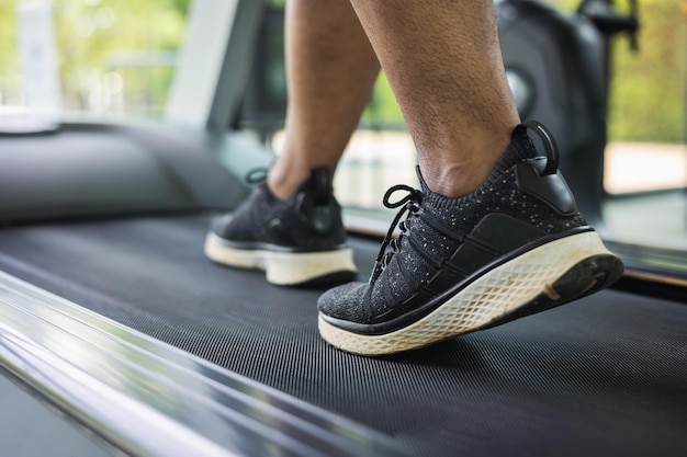 Młody Sportowiec Bieganie Na Bieżni. Bliska Mężczyzna Biegacz ćwiczenia Siłowni. Fitness Człowiek Jogging Na Sobie Odzież Sportową. Trening I Zdrowy