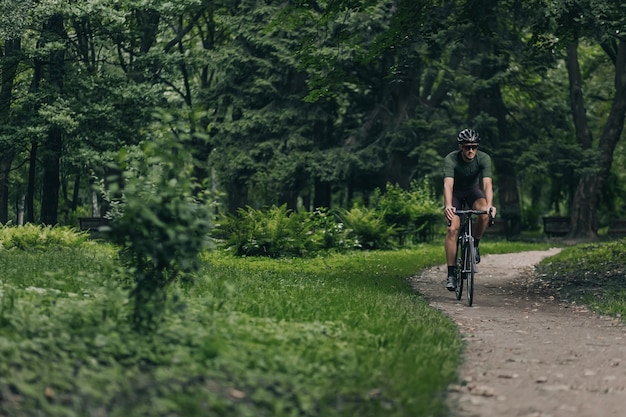 Młody sportowiec cieszący się poranną jazdą na rowerze w letnim parku