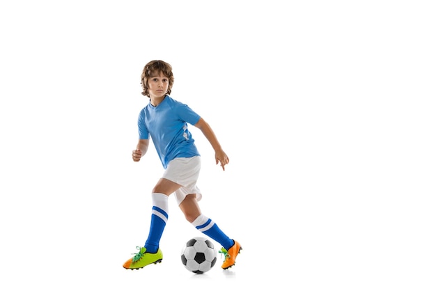 Młody sportowiec piłka nożna piłkarz dziecko gra w piłkę nożną na białym tle studio Pojęcie hobby gry sportowej