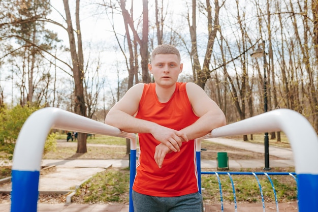 Młody sportowiec w autentycznym czerwonym stroju sportowym Portret modnego i aktywnego sportowca Portret młodego i modnego faceta w czerwonej koszulce Model autentyczności