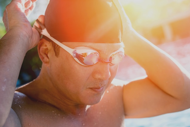 Zdjęcie młody sportowy mężczyzna dopłynięcie w pływackim basenie