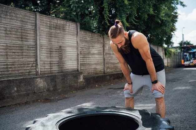 Młody sprawny mężczyzna wyczerpany odzyskuje plenerową gym bierze przerwę