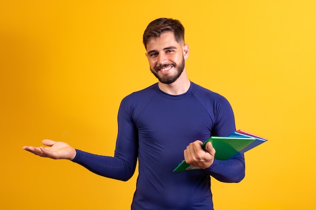 Młody student chłopiec na żółtym tle. szczęśliwy uczeń chłopak