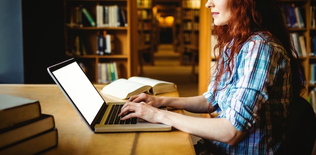 Zdjęcie młody student studiujący w bibliotece na uniwersytecie