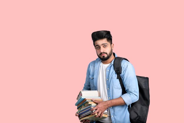 Młody student z plecakiem trzymający książki casualowy strój indyjski model pakistański