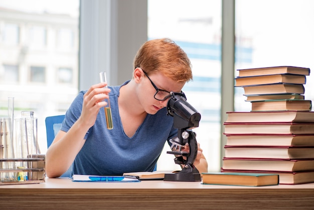 Zdjęcie młody student zmęczony i wyczerpany przygotowuje się do egzaminu chemicznego