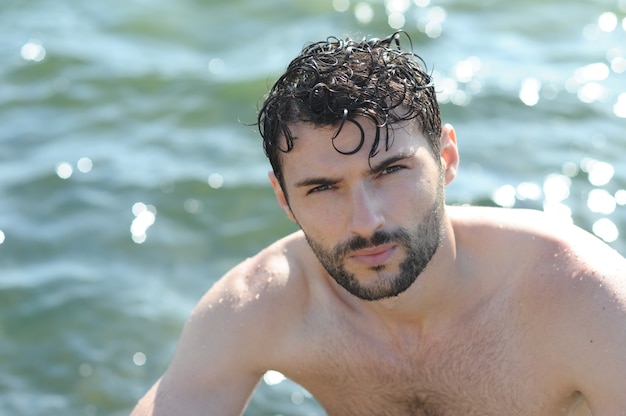 Młody stylowy mężczyzna portret topless w wodzie morskiej