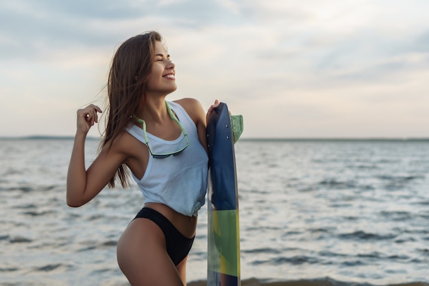 Młody Surfingowiec Pozuje Z Jej Surfboard Na Plaży