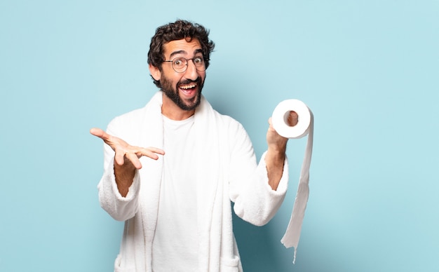 Młody szalony brodaty mężczyzna na sobie szlafrok i papier toaletowy