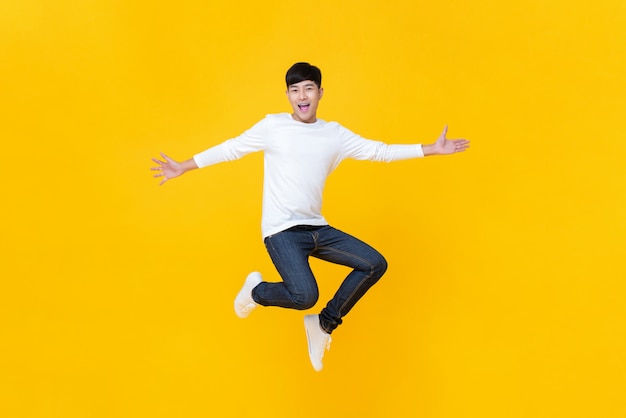 Młody szczęśliwy koreański nastolatek skacze z zadowoleniem