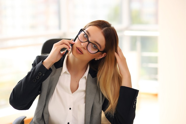 Młody szczęśliwy uśmiechnięty bizneswoman pracuje w biurze