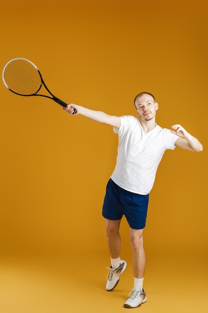 Młody tenisista gra w tenisa na żółto