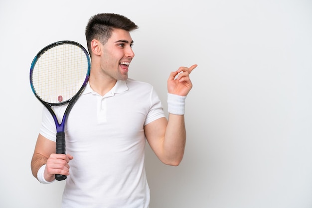 Młody tenisista mężczyzna na białym tle zamierza zrealizować rozwiązanie, podnosząc palec w górę