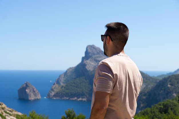 Młody turysta mężczyzna na plecach patrzący na Morze Śródziemne na Majorce Hiszpania