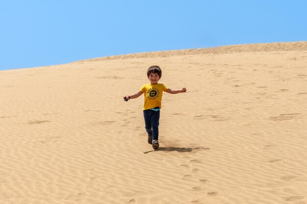 Młody turysta uśmiechający się na wydmach Maspalomas Gran Canaria Wyspy Kanaryjskie