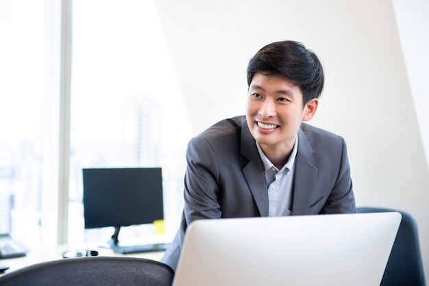 Młody uśmiechnięty Azjatycki biznesmen w biurze