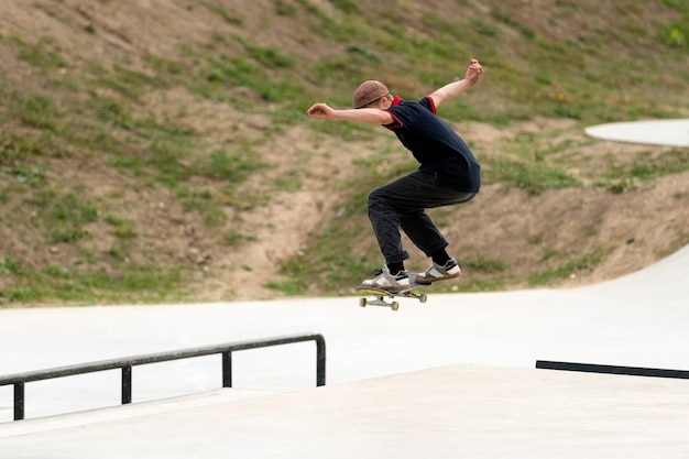 Młody Zawodnik Deskorolki Robi Skok W Betonowym Skateparku.