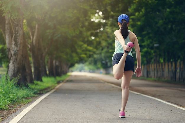 Młody zdrowy fitness kobieta lekkoatletka rozciąganie nogi