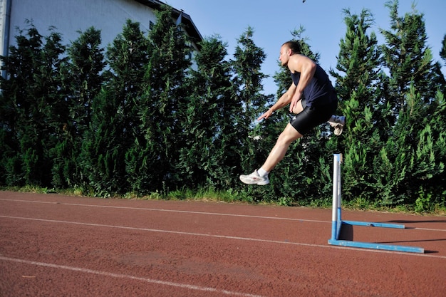 Młody Zdrowy Mężczyzna Biega Na Sportowym Torze Wyścigowym I Reprezentuje Koncepcję Rodzaju I Prędkości