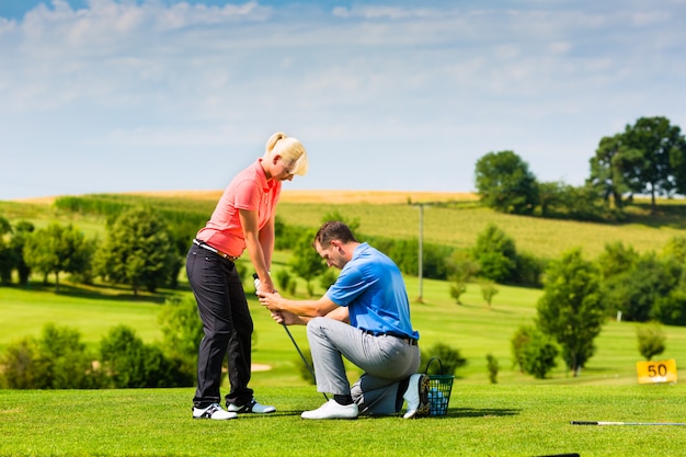 Młody żeński golfowy gracz na kursie