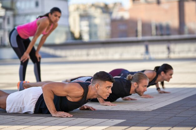 Młodzi Fitnessowi Mężczyźni I Kobiety Robią Pompki W Mieście