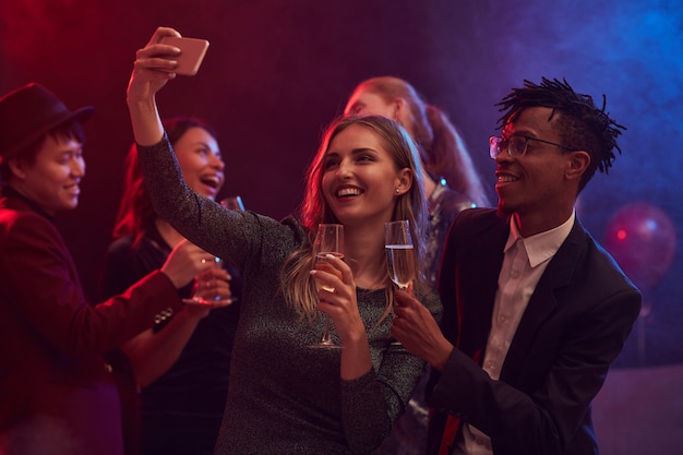Młodzi ludzie biorący selfie w klubie nocnym