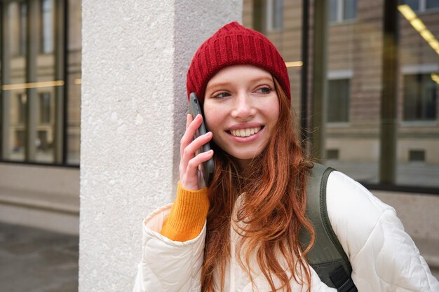 Młodzi ludzie i połączenie mobilne szczęśliwa ruda dziewczyna rozmawia przez telefon sprawia, że rozmowa telefoniczna wyróżnia się
