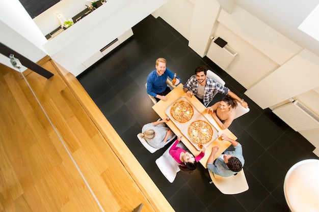 Młodzi ludzie jadają posiłek w jadalni w nowoczesnym domu