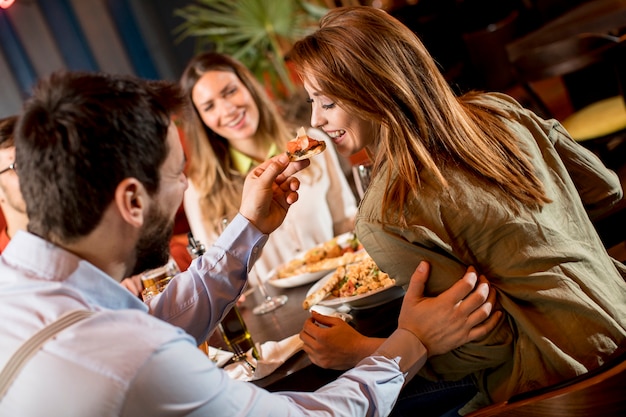 Młodzi ludzie obiadują w restauracji.