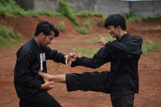 Młodzi mężczyźni ćwiczący karate na świeżym powietrzu