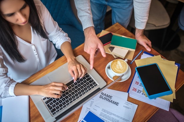 Młodzi projektanci pracujący na laptopie w restauracji