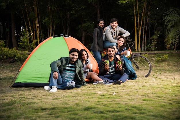 Młodzi Przyjaciele Z Azji I Indii Dobrze Się Bawią Na Wycieczce Na Kemping, Relaksując Się Na Wakacjach Z Zabawą Na Zewnątrz Namiotów