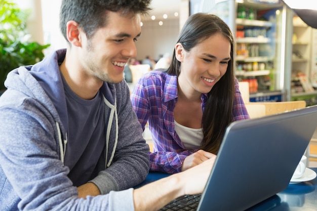 Młodzi studenci robi zadanie na laptopie razem