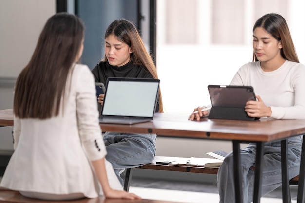 Młodzi studenci z Azji spotykają się z doradcą nauczyciela lub korepetytorem, aby omówić projekt