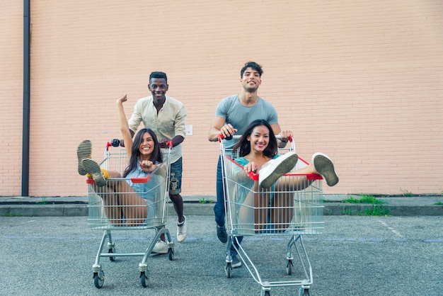Młodzi Szczęśliwi Przyjaciele Biega Z Wózek Na Zakupy