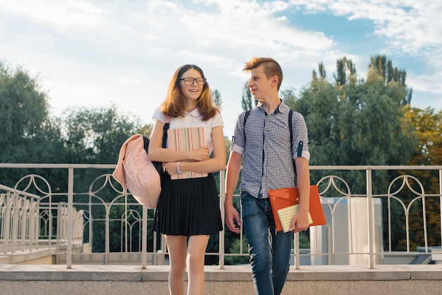 Młodzież uczniowie z plecakami, podręcznikami, chodzą do szkoły