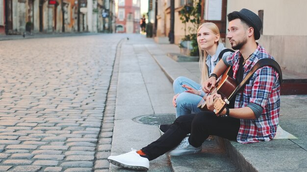 Mman I Kobieta Siedzą Na Chodniku, Grają Na Gitarze I Odpoczywają