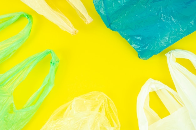 Zdjęcie mnóstwo kolorowych plastikowych toreb na żółtym tle