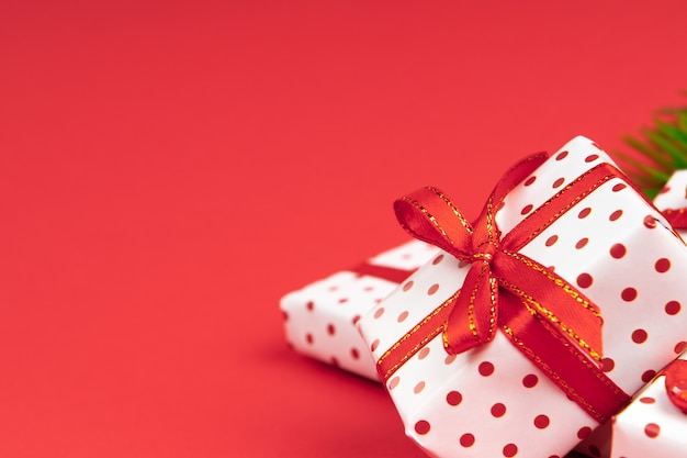 Mnóstwo prezentów noworocznych zawiniętych w polkę prezentową z świąteczną wstążką na czerwono