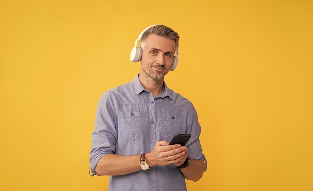 Mobilna aplikacja muzyczna nowy facet z aplikacji w słuchawkach rozmawia na smartfonie