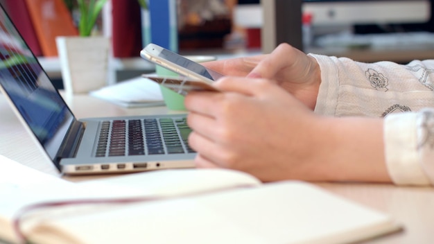 Zdjęcie mobilne rozwiązania płatnicze ręce kobiety trzymające kartę kredytową i korzystające ze smartfona
