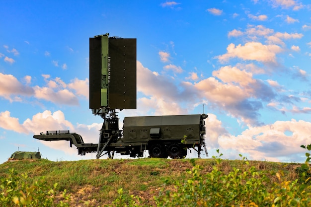 Mobilny radar lotnictwa wojskowego stoi na wzgórzu na tle błękitnego nieba z pięknymi chmurami