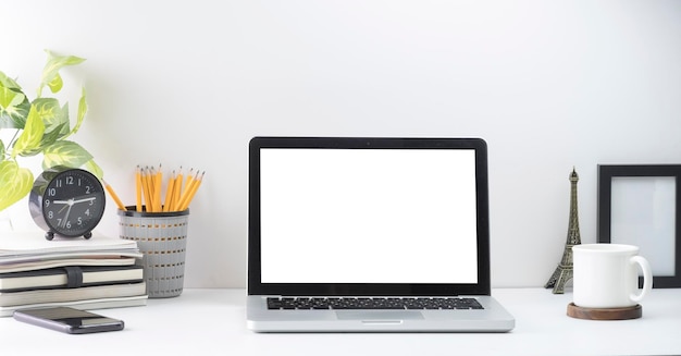 Mock up laptop laptop ramki na zdjęcia filiżanki kawy i uchwyt na ołówek na białym biurku