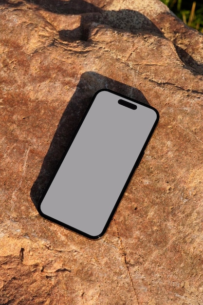 Mockup iPhone'a na zewnątrz na skalistej powierzchni