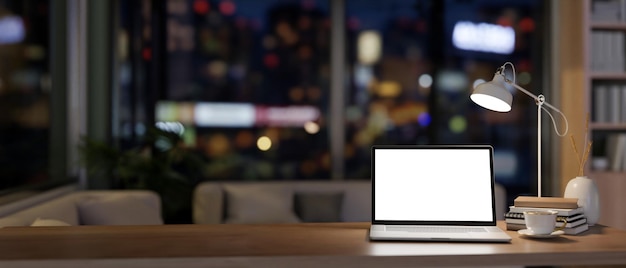 Mockup laptopa na drewnianym biurku w współczesnym biurze domowym w nocy oświetlony słabymi światłami