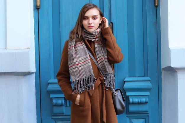 Zdjęcie moda młoda kobieta na zewnątrz na sobie płaszcz, szalik i torebkę