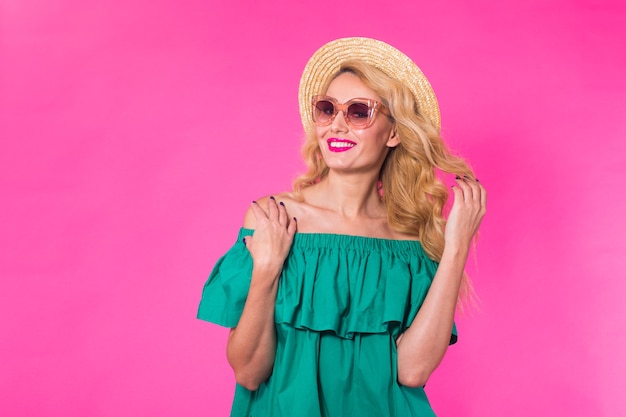 Moda piękny portret dziewczyny glamour, słodkie emocje, stylowe okulary przeciwsłoneczne hipster na różowej ścianie z copyspace.