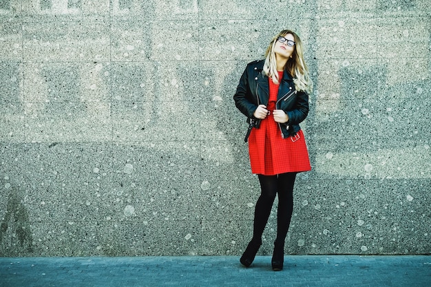 Moda piękny portret kobiety hipster w stylowy strój dorywczo lato pozowanie na ścianie.