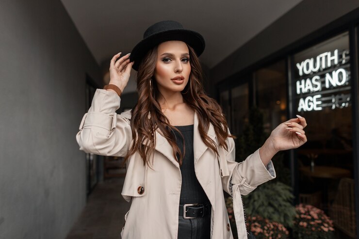 Zdjęcie moda portret modelki pięknej seksownej brunetki z rocznika kapeluszem w modnym szarym płaszczu spaceruje po mieście