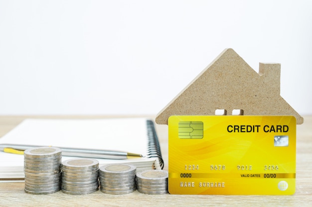 Model domu i karta kredytowa na stole dla koncepcji finansów i bankowości